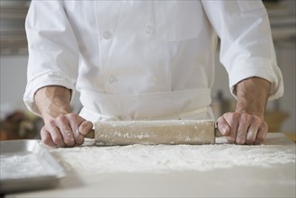 Pastry chef rolling out dough.
