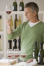 Man looking at glass of wine.