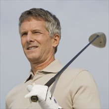 Man holding golf club on shoulder.