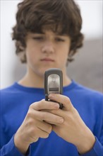 Teenaged boy looking at cell phone.