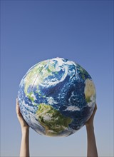 Person holding globe in air.