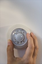 Man adjusting thermostat.