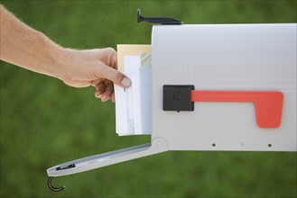 Man taking mail out of mailbox.