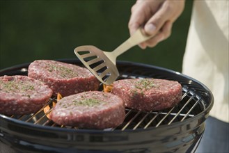 Close up of hamburgers on barbecue grill.