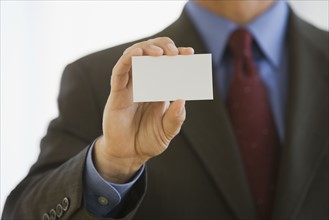 Businessman holding up business card.