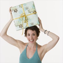 Woman holding gift on head.