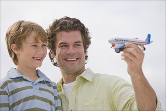 Father and son playing with toy airplane.