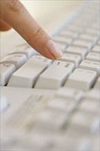 Woman pressing Enter key on computer keyboard.
