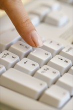 Woman pressing number key on computer keyboard.