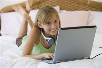 Teenaged girl typing on laptop.