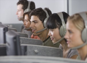 College students wearing headsets in computer lab.