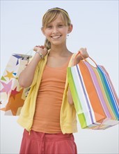 Teenaged girl holding shopping bags.