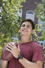 Young man holding football.