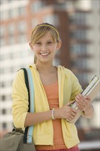 Teenaged girl holding school books.