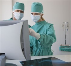 Doctors looking at computer monitor.
