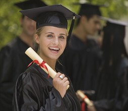 Female college graduate holding diploma.