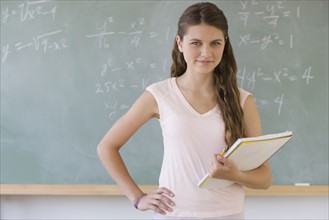 Girl standing in front of blackboard.