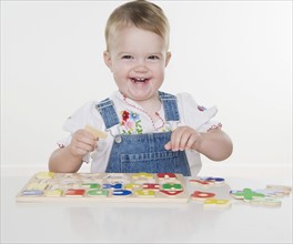 Female toddler playing with a puzzle. Date : 2006