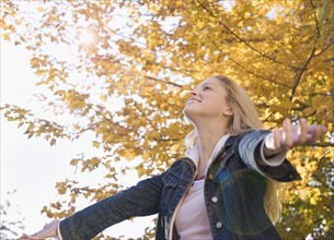 Woman with outstretched arms on a fall day. Date : 2006