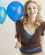 Woman holding balloons and smiling. Date : 2006