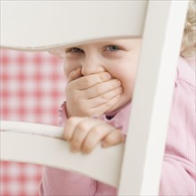 Portrait of child looking through a chair. Date : 2006