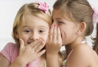 Young girl telling sister a secret. Date : 2006