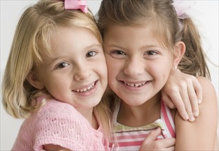 Two young sisters hugging and smiling. Date : 2006