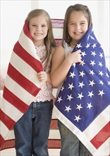Portrait of sisters wrapped in American flag. Date : 2006