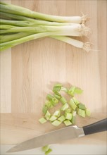 Chopped green onions on cutting board. Date : 2006