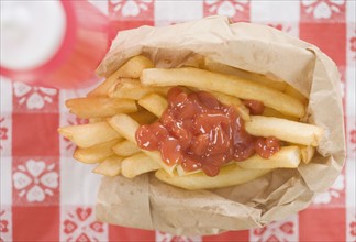 High angle view of French fries and ketchup. Date : 2006