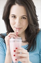 Woman drinking milkshake with straw. Date : 2007