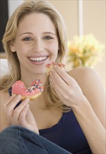 Woman eating frosted donut. Date : 2007