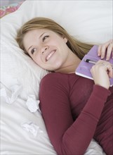Teenage girl holding journal on bed. Date : 2007