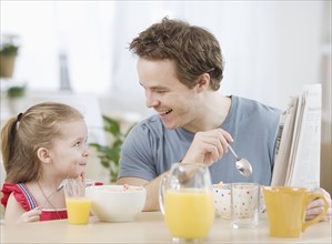 Father and daughter eating breakfast. Date : 2007