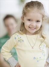 Girl smiling with father in background. Date : 2007