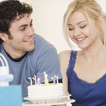 Man watching girlfriend smile at birthday cake. Date : 2007