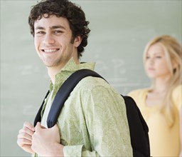 Man wearing backpack in front of blackboard. Date : 2007