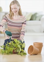 Woman putting plant in pot. Date : 2007