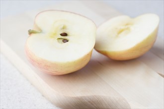 Halved apple on cutting board. Date : 2006