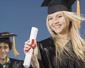 Woman wearing graduation cap and gown with diploma. Date : 2007