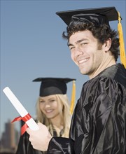 Man wearing graduation cap and gown with diploma. Date : 2007