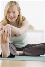 Woman stretching on yoga mat. Date : 2007