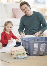 Father and daughter folding laundry. Date : 2007