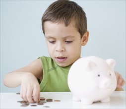 Boy counting coins from piggy bank. Date : 2007