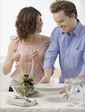 Couple setting table and tossing salad. Date : 2007
