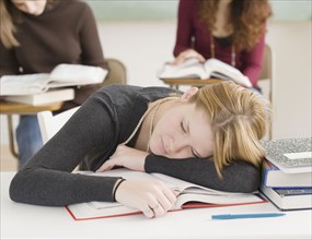 Female student sleeping on desk. Date : 2007