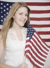 Portrait of teenage girl holding American flag. Date : 2007