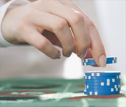 Woman picking up poker chips. Date : 2007