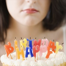 Woman frowning at blown out birthday candles. Date : 2007
