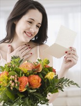Woman reading card on flower bouquet. Date : 2007